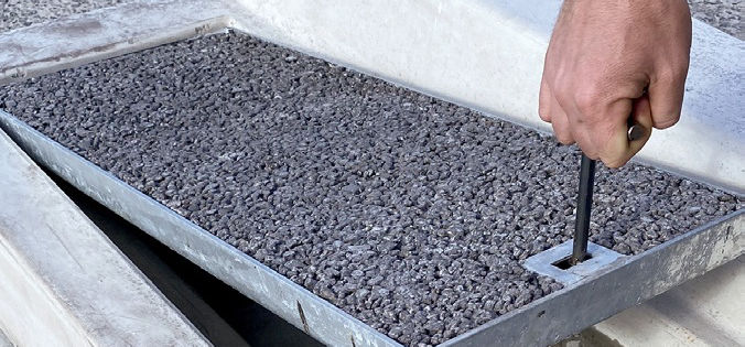 A hand lifting the galvanised tray out of the EFFI body using the cast-in Gatic locator